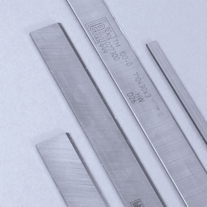 A group of sharpenable planer knives on a light grey background